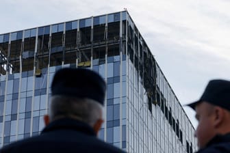 Sicherheitsbeamte vor einem beschädigten Moskauer Bürogebäude, in das laut russischen Medien Drohnen geflogen sind.
