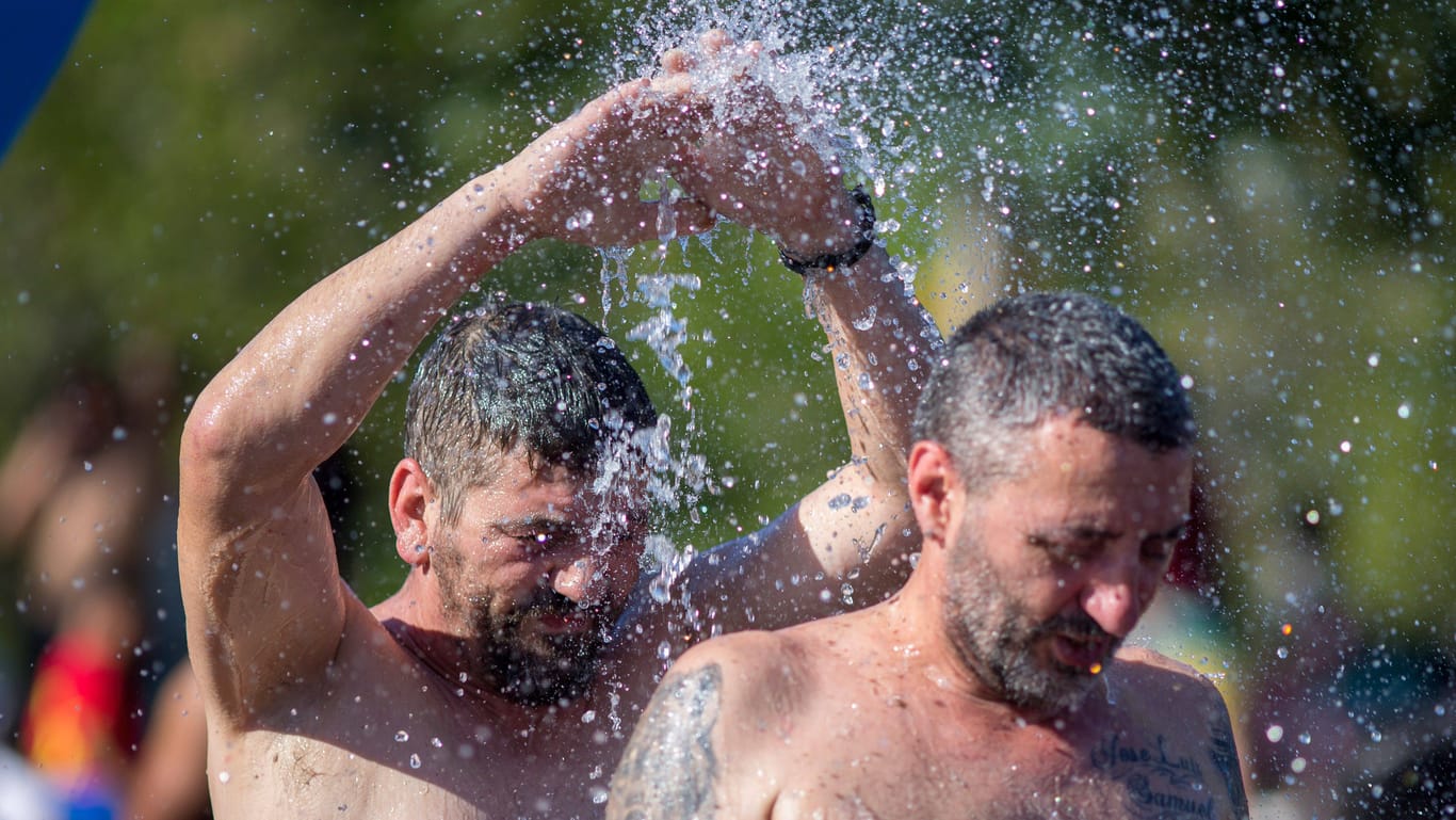 Am Stadtstrand von Madrid suchen zwei Männer nach Abkühlung: Der spanische Wetterdienst spricht von "einem der heißesten Sommer" in vielen Jahrzehnten. Der weltweite Temperaturrekord wurde Anfang Juli bereits gebrochen.