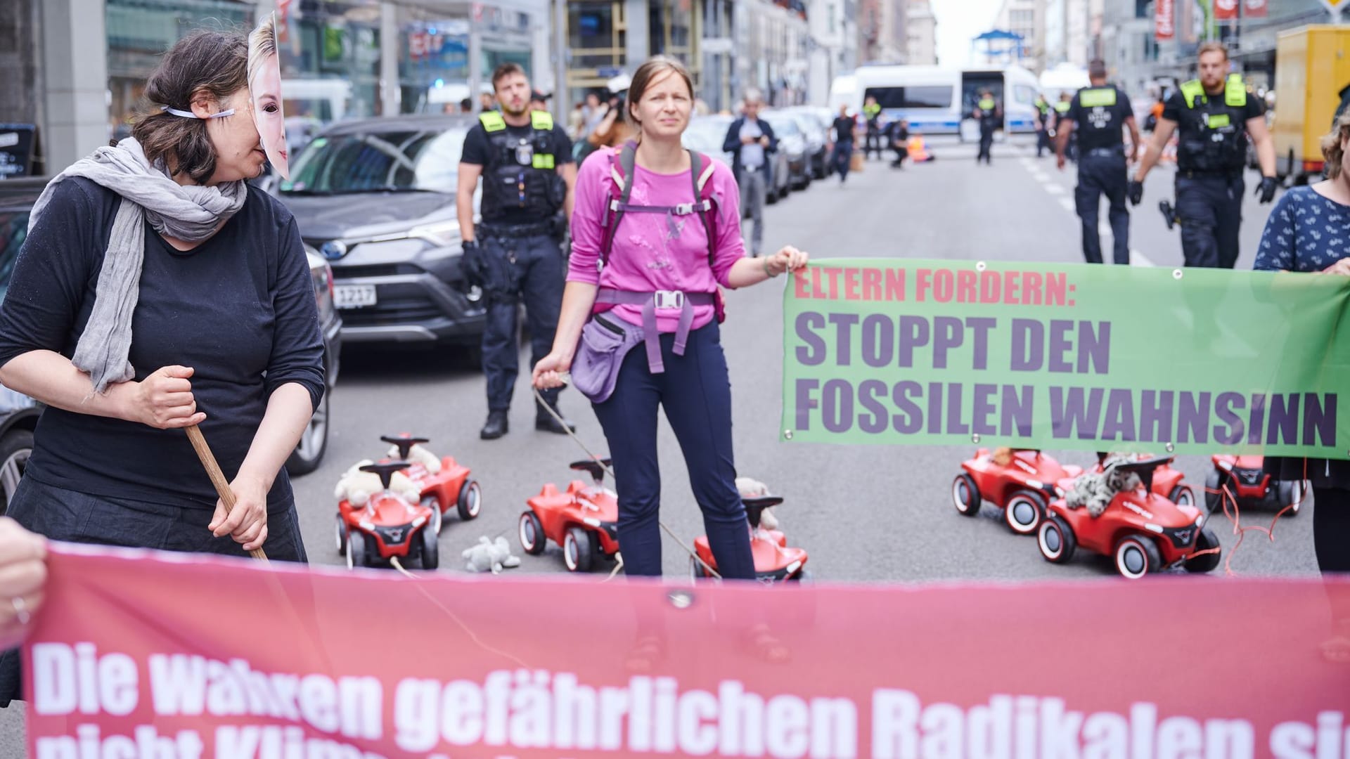 "Stoppt den fossilen Wahnsinn" steht auf einem Transparent: Die Elterngruppe "Jetzt oder Nie - Eltern gegen die Fossilindustrie" hat sich dem Protest der "Letzten Generation" angeschlossen.