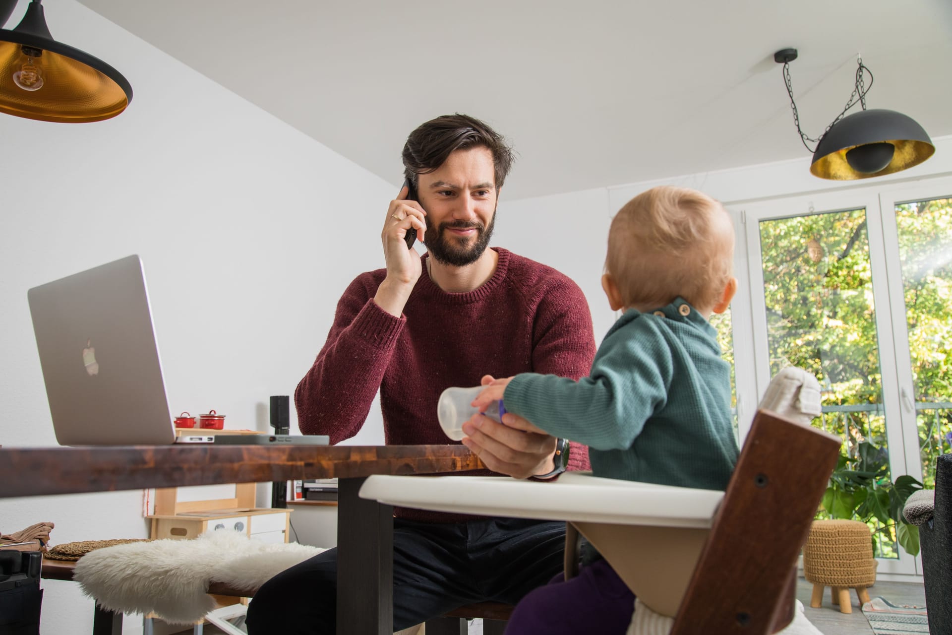 Ein Vater füttert sein Kind: Leistungen wie das Elterngeld gibt es nur, wenn Ihr zu versteuerndes Einkommen einen bestimmten Betrag nicht übersteigt.