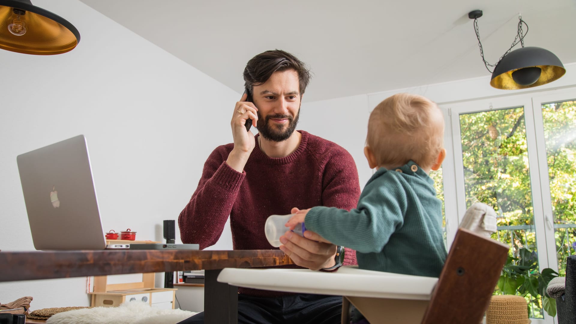 Ein Vater füttert sein Kind: Leistungen wie das Elterngeld gibt es nur, wenn Ihr zu versteuerndes Einkommen einen bestimmten Betrag nicht übersteigt.