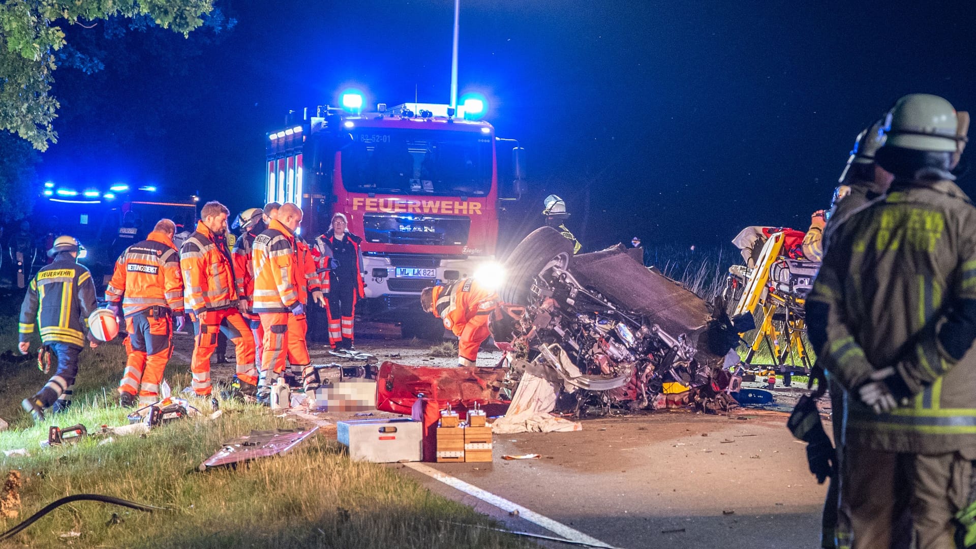 Einsatzkräfte stehen um das völlig zerstörte Fahrzeug herum: Dem Fahrer konnte nicht mehr geholfen werden.