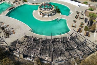 Die Sonnenliegen und eine Bar am Pool eines Hotels wurden durch Feuer zerstört: Im Südosten der Ferieninsel Rhodos kämpfen die Menschen gegen die Flammen.
