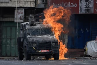 Israelisches Militärfahrzeug brennt nach Wurf eines Molotowcocktails: Die Gewalt zwischen Israelis und Palästinensern eskaliert immer weiter.