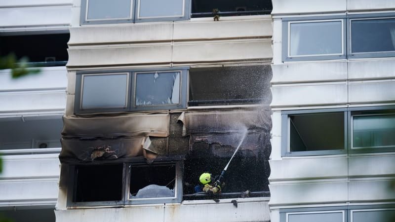 Ein Feuerwehrmann löscht die letzten Überreste der Fassade: Die Wohnung lag in 30 Metern Höhe. Ein Feuerwehrmann löscht die letzten Überreste der Fassade: Die Wohnung lag in 30 Metern Höhe.