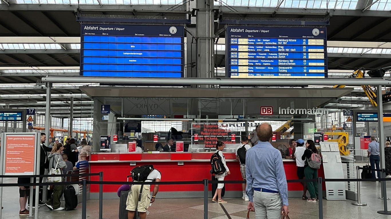 Im Münchner Hauptbahnhof warten Menschen wegen Zugausfällen nach Unwettern vor einer Anzeigetafel: Ein Unwetter mit Sturm und Regen zog in der Nacht zu Mittwoch über Bayern hinweg. Der Bahnverkehr wird in weiten Teilen des Freistaats lahmgelegt.