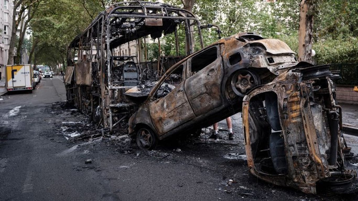 Ausgebrannte Autos und ein Bus stehen in einer Straße in Lyon: Dort gab es besonders heftige Ausschreitungen.