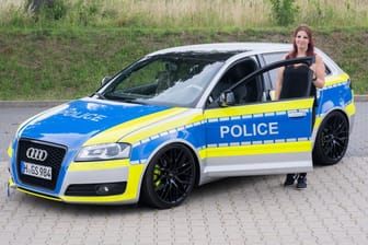Auto-Tunerin Svenja Geertz steht neben ihrem Audi, der ähnlich wie ein Polizeifahrzeug foliert ist.