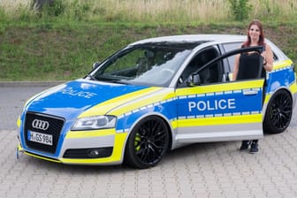 Auto-Tunerin Svenja Geertz steht neben ihrem Audi, der ähnlich wie ein Polizeifahrzeug foliert ist.