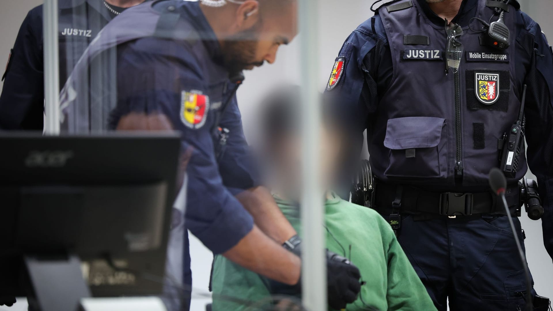 Justizbeamte bringen den Angeklagten Ibrahim A. an seinen Platz im Gerichtssaal: Nach der Tat habe er kniend auf dem Bahnsteig gesessen, berichtet ein Polizist. Justizbeamte bringen den Angeklagten Ibrahim A. an seinen Platz im Gerichtssaal: Nach der Tat habe er kniend auf dem Bahnsteig gesessen, berichtet ein Polizist.