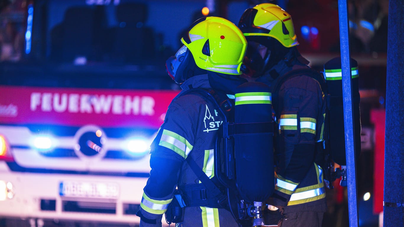 Zwei Feuerwehrleute stehen in Bereitschaft (Symbolbild): Die Rettungskräfte fanden den Mann, nachdem sie das Feuer gelöscht hatten.