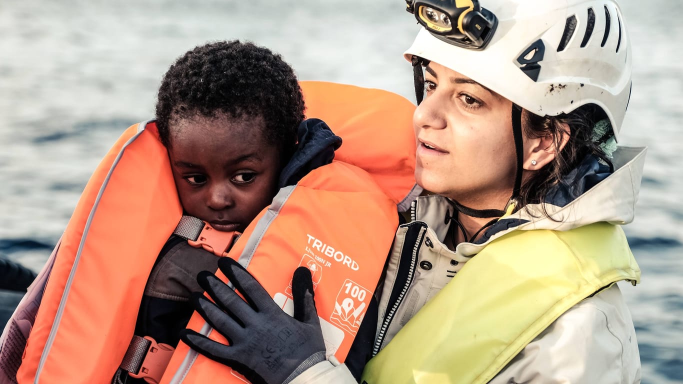 Eine Mitarbeiterin der Seenotrettungsorganisation Sea Watch hält einen kleinen Jungen im Arm (Archivbild): Jedes Jahr ertrinken mehr als 1.500 Menschen bei ihrer Flucht über das Mittelmeer. Die Dunkelziffer gilt als deutlich höher.