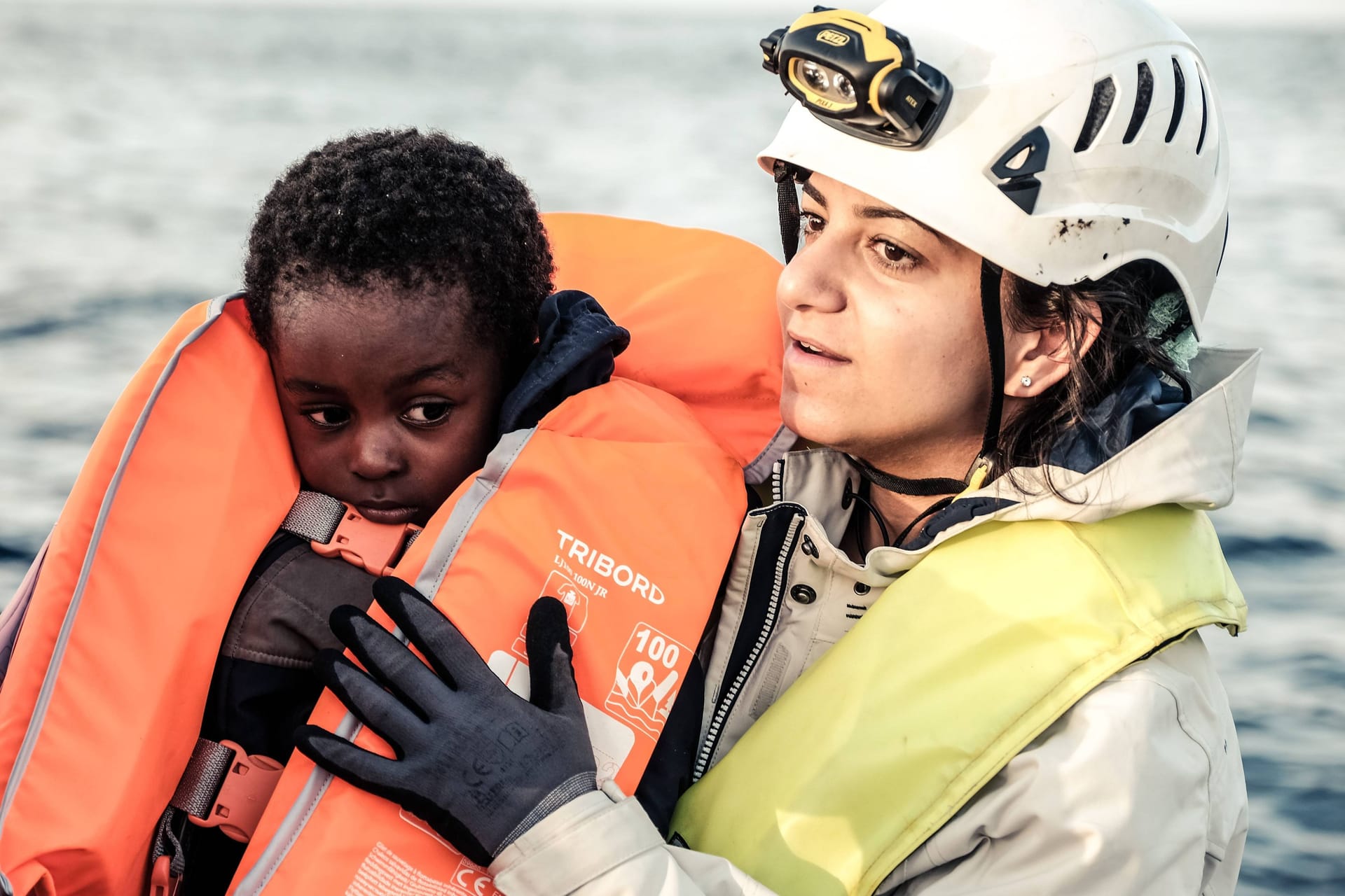 Eine Mitarbeiterin der Seenotrettungsorganisation Sea Watch hält einen kleinen Jungen im Arm (Archivbild): Jedes Jahr ertrinken mehr als 1.500 Menschen bei ihrer Flucht über das Mittelmeer. Die Dunkelziffer gilt als deutlich höher.