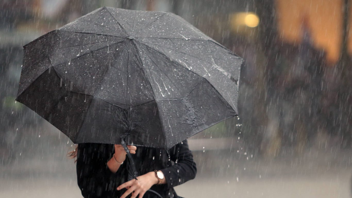 Frau mit Regenschirm in Frankfurt: In Teilen Hessens wird es den ganzen Tag über nass.