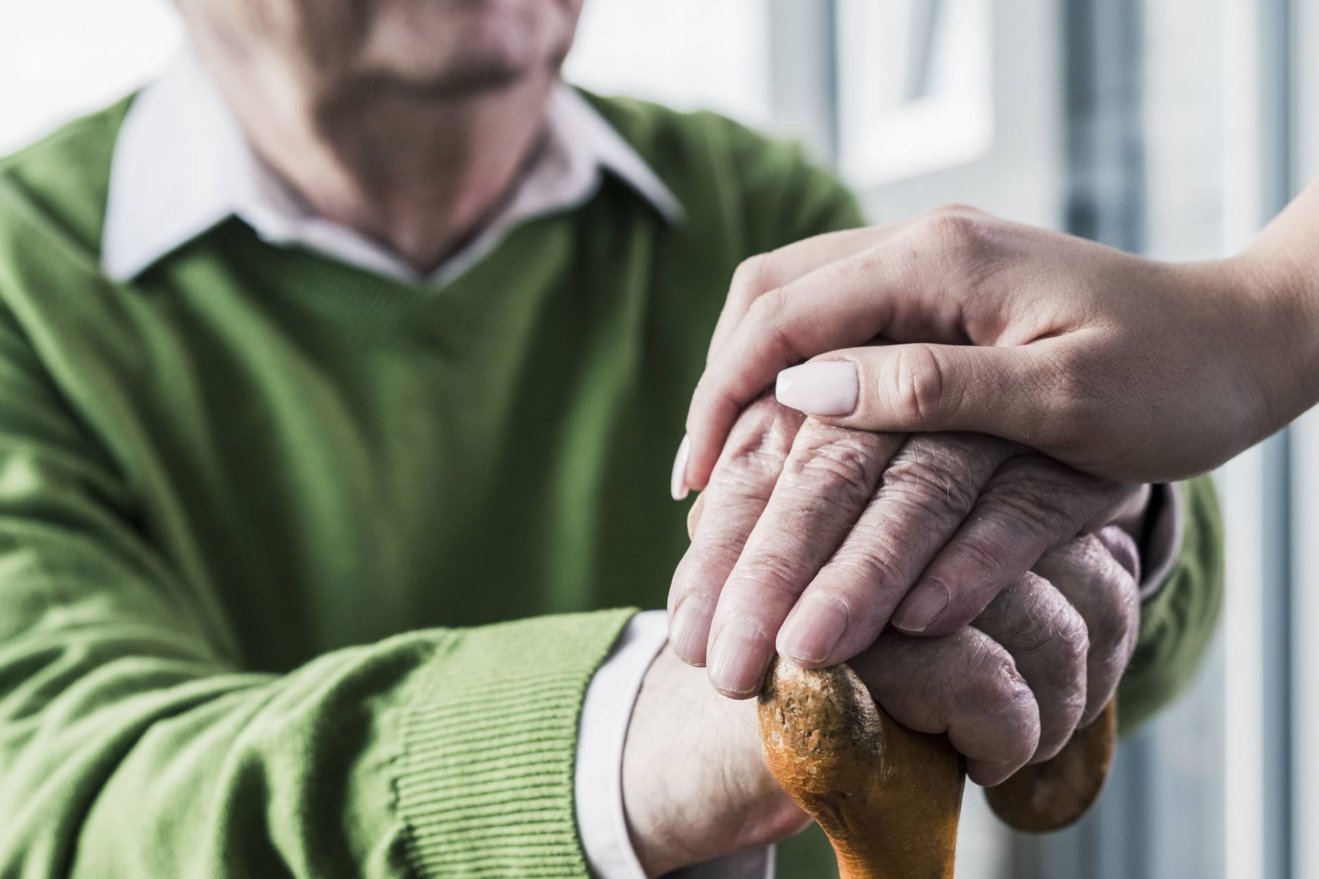 Eine Pflegekraft legt ihre Hand auf die eines Patienten (Symbolbild): In 70 Fällen soll ein Pfleger Bewohner einer Einrichtung missbraucht haben.