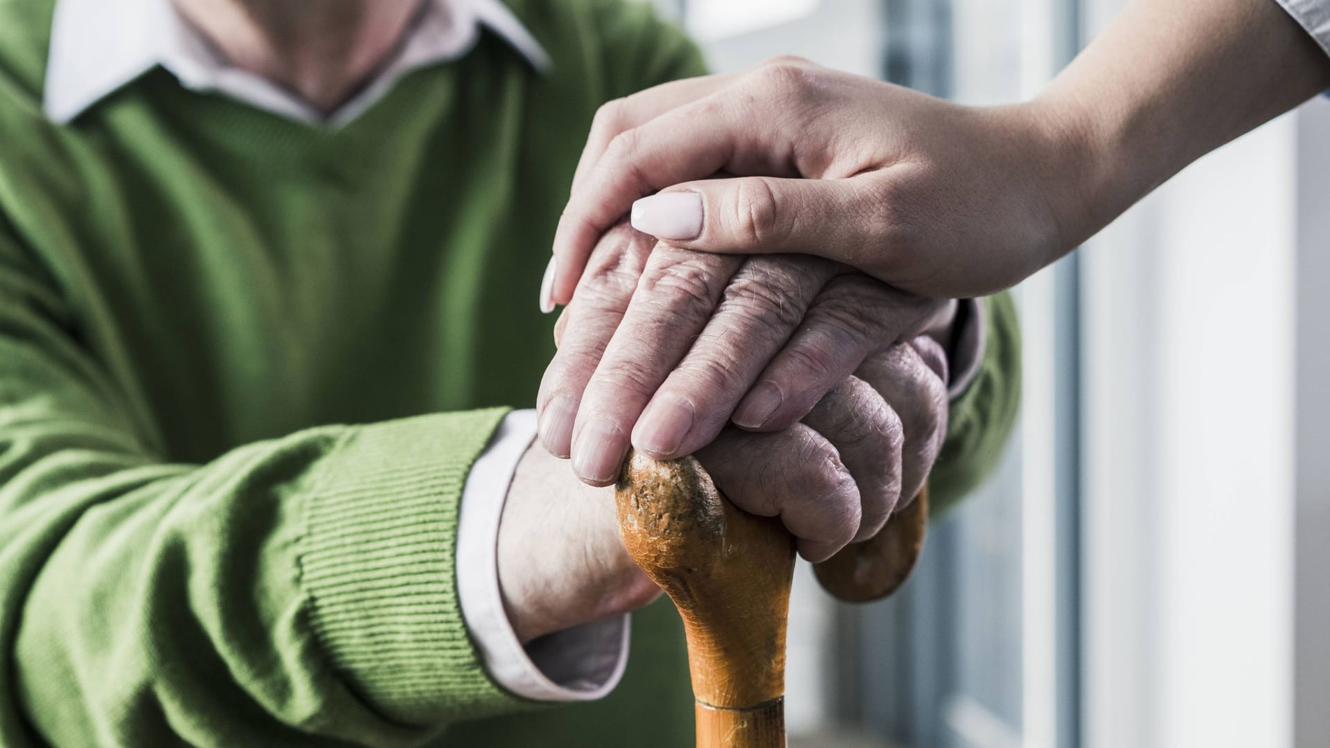 Eine Pflegekraft legt ihre Hand auf die eines Patienten (Symbolbild): In 70 Fällen soll ein Pfleger Bewohner einer Einrichtung missbraucht haben.