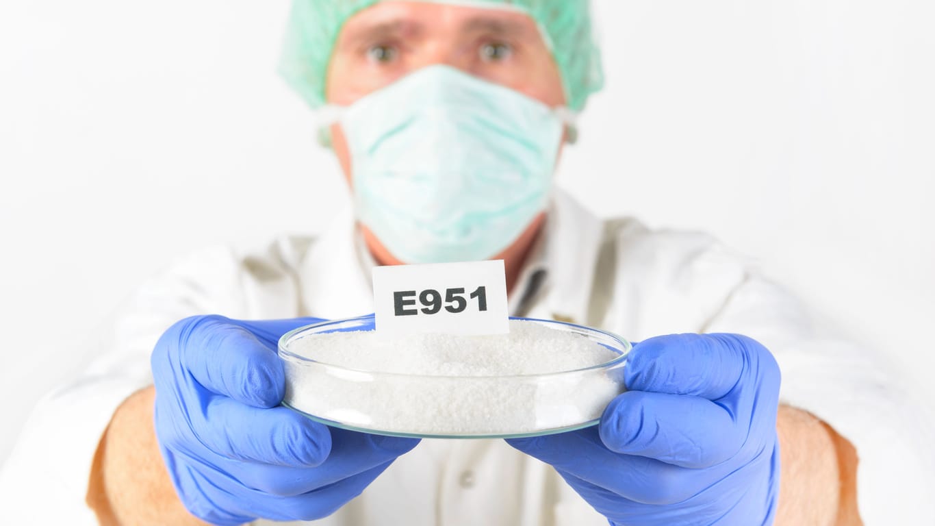 Ein Forscher hält eine Schale mit Aspartam: Der Süßstoff muss auf Lebensmitteln mit seinem Namen oder der E-Nummer E951 gekennzeichnet werden.