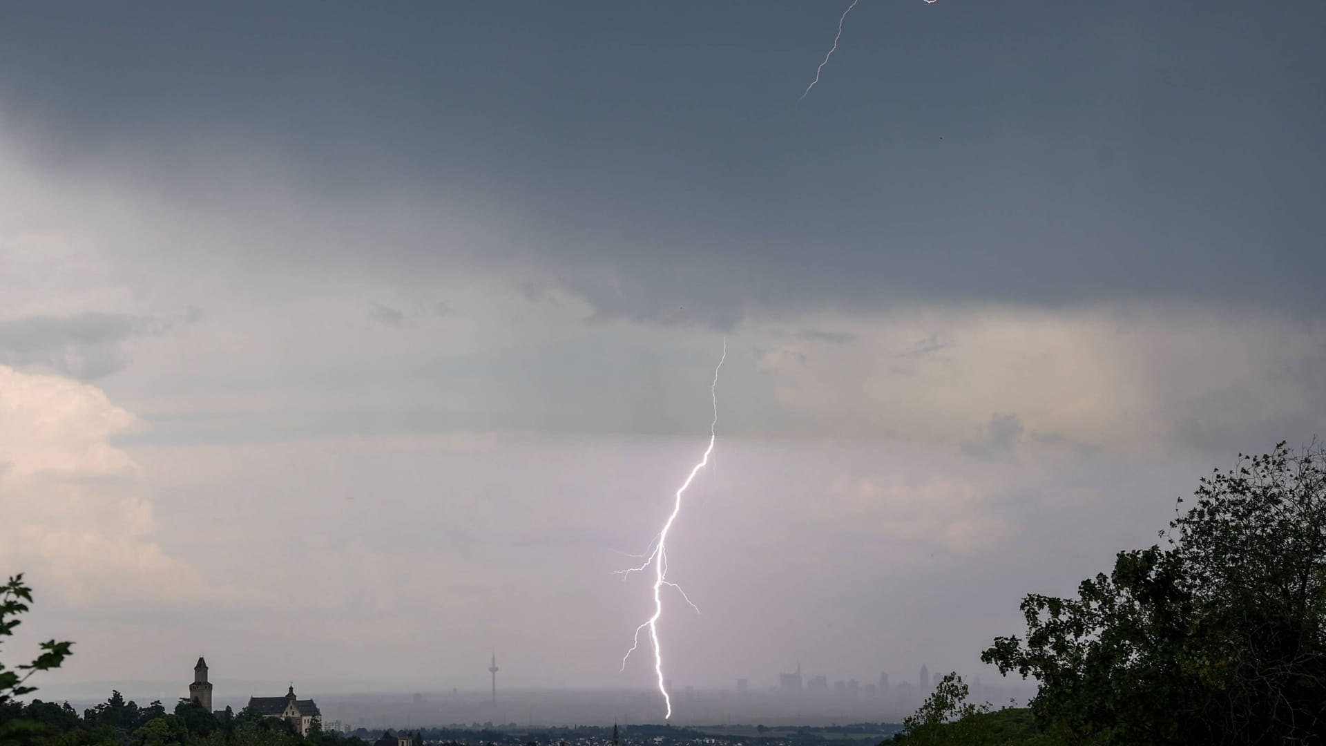 Der Blitz eines Gewitters ist von Kronberg aus über der Skyline von Frankfurt am Main zu sehen.