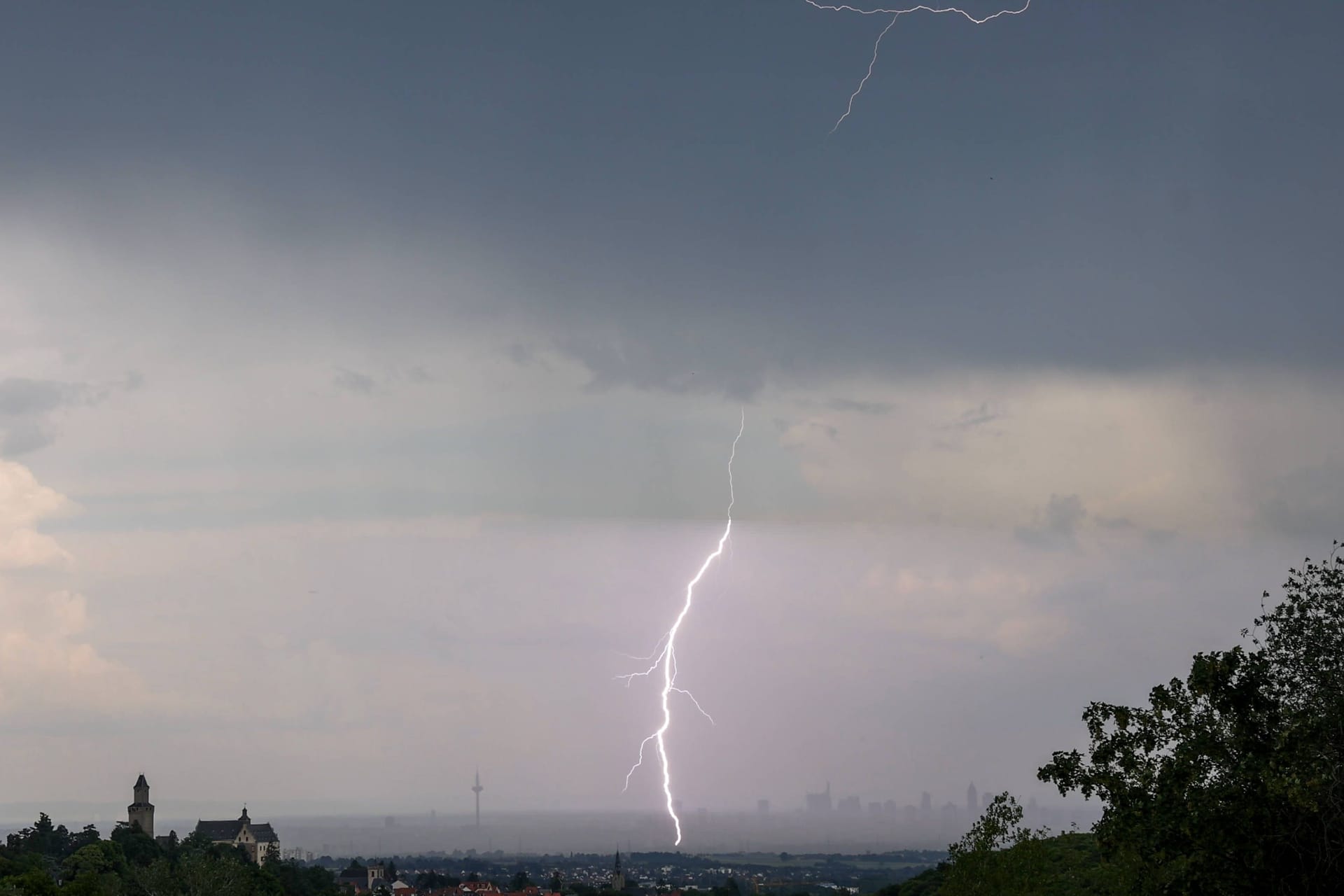 Der Blitz eines Gewitters ist von Kronberg aus über der Skyline von Frankfurt am Main zu sehen.