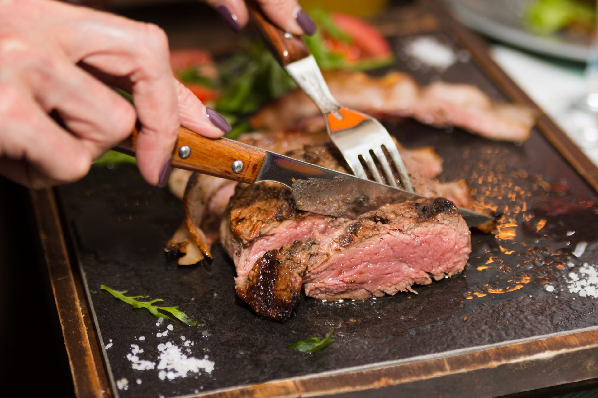 Jemand schneidet ein Stück Fleisch