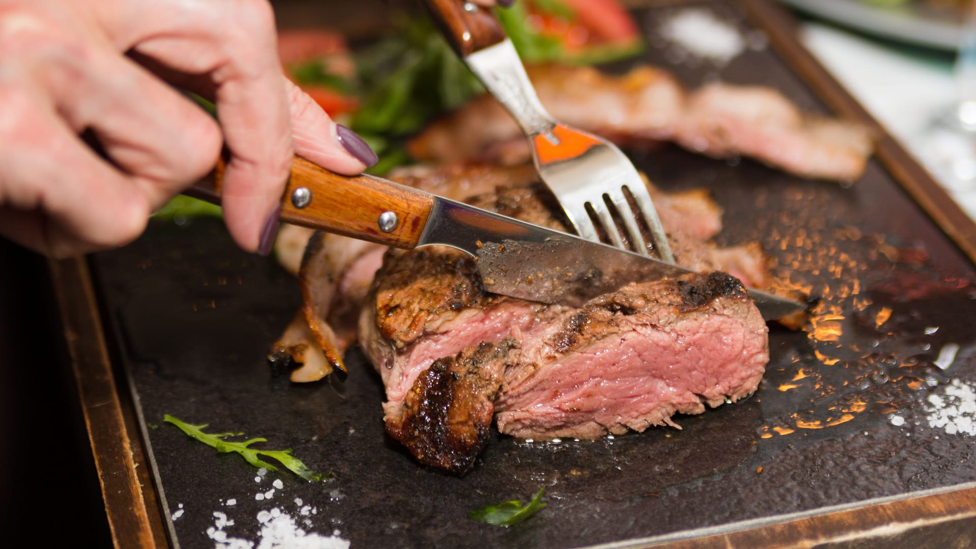 Jemand schneidet ein Stück Fleisch