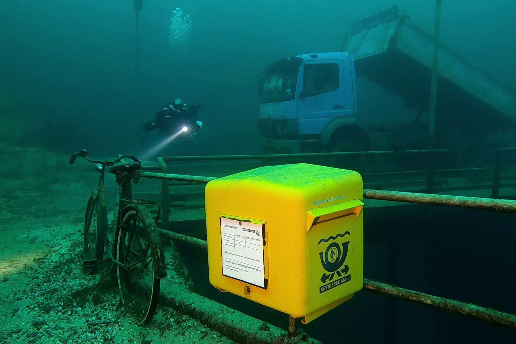 Ein gelber Briefkasten der Marke Eigenbau: Er ist im Kreidesee in einer Tiefe von 19 Metern unter Normalnull angebracht.