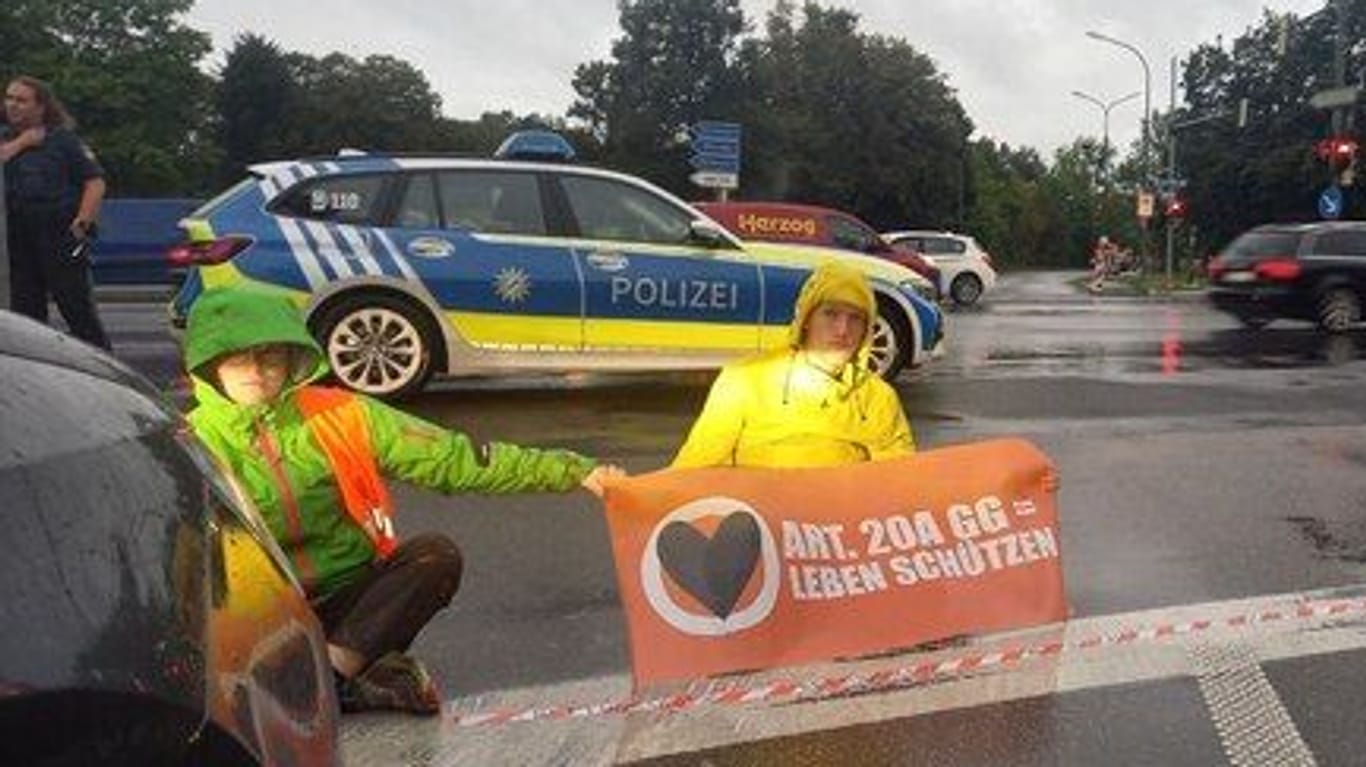 Auch der Regen hält sie nicht auf: Am Montag protestiert die "Letzte Generation" erneut in München.