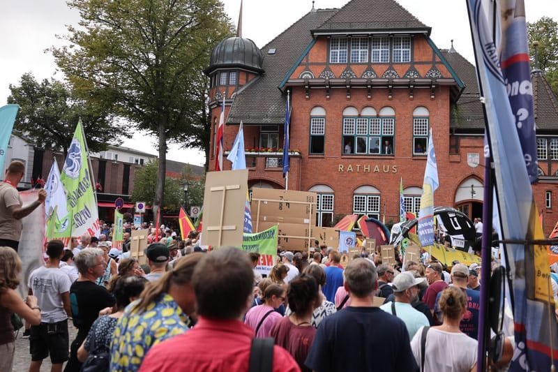 Teilnehmer der Demonstration stehen vor dem Rathaus.