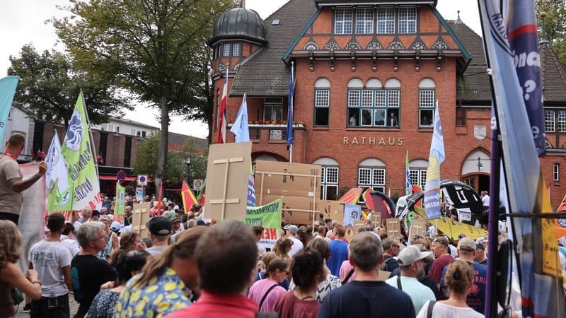 Teilnehmer der Demonstration stehen vor dem Rathaus.