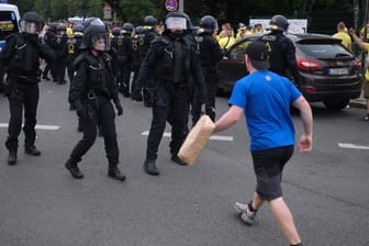 Ein Fußballfan des 1. FC Lokomotive Leipzig steht auf einer Kreuzung der Polizei gegenüber. Nach dem Fußballspiel gegen Eintracht Frankfurt kam es zu Auseinandersetzungen.