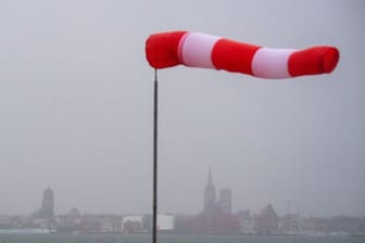 Ein Windsack steht fast horizontal in der Luft und zeigt den Wind an: Sturmböen und Gewittern sind in Südbayern zu erwarten.