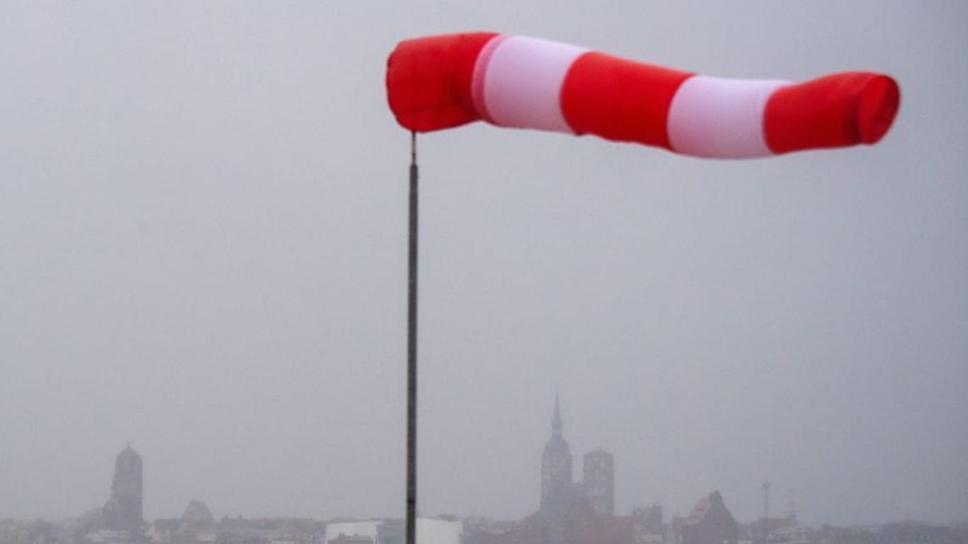 Ein Windsack steht fast horizontal in der Luft und zeigt den Wind an: Sturmböen und Gewittern sind in Südbayern zu erwarten.