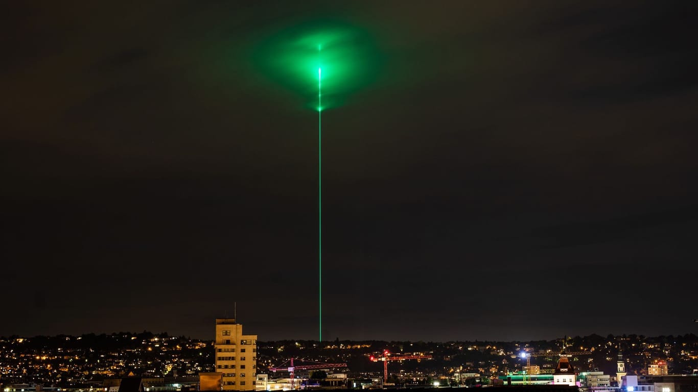 Ein grüner Laser strahlt am nächtlichen Himmel über Stuttgart: Ein Laser der Firma Trumpf soll zum 100. Firmenjubiläum als besondere "Geburtstagskerze" am Himmel leuchten.