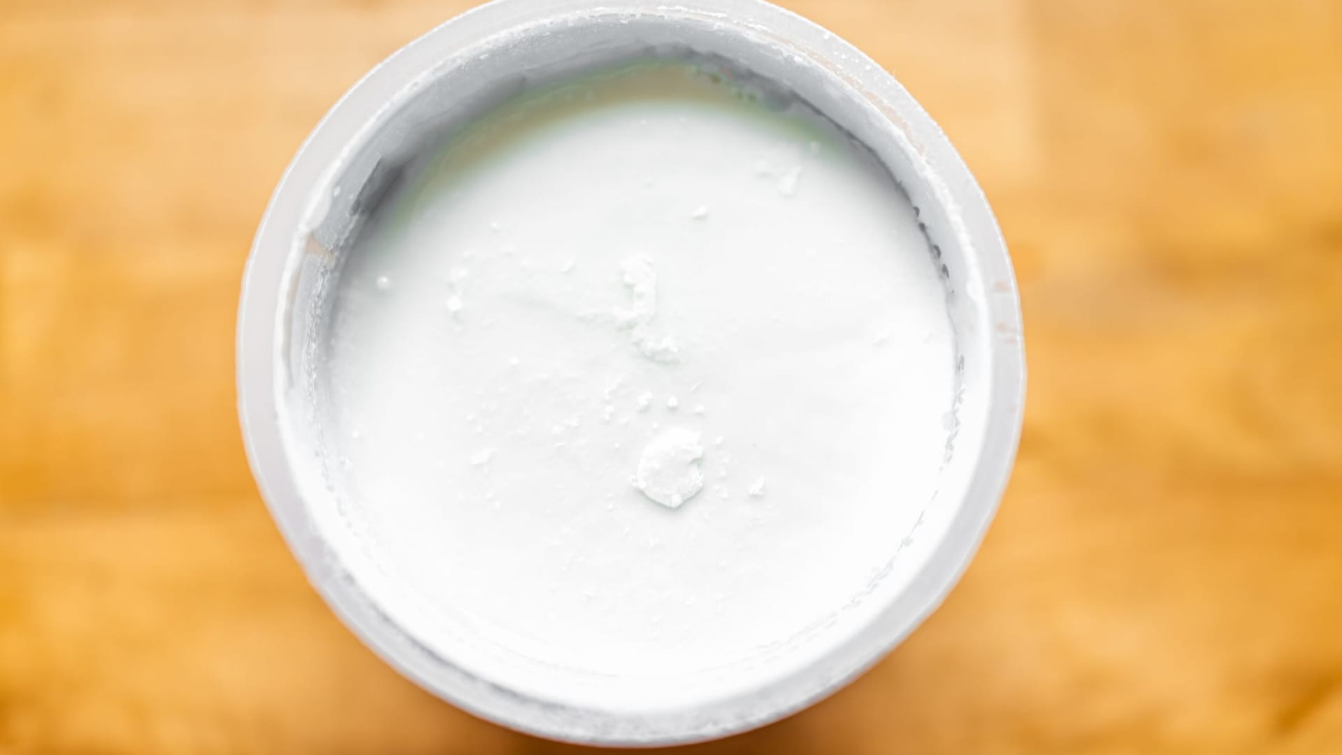 Geöffneter Joghurt: Auf der Oberfläche sammelt sich Flüssigkeit. Geöffneter Joghurt: Auf der Oberfläche sammelt sich Flüssigkeit.
