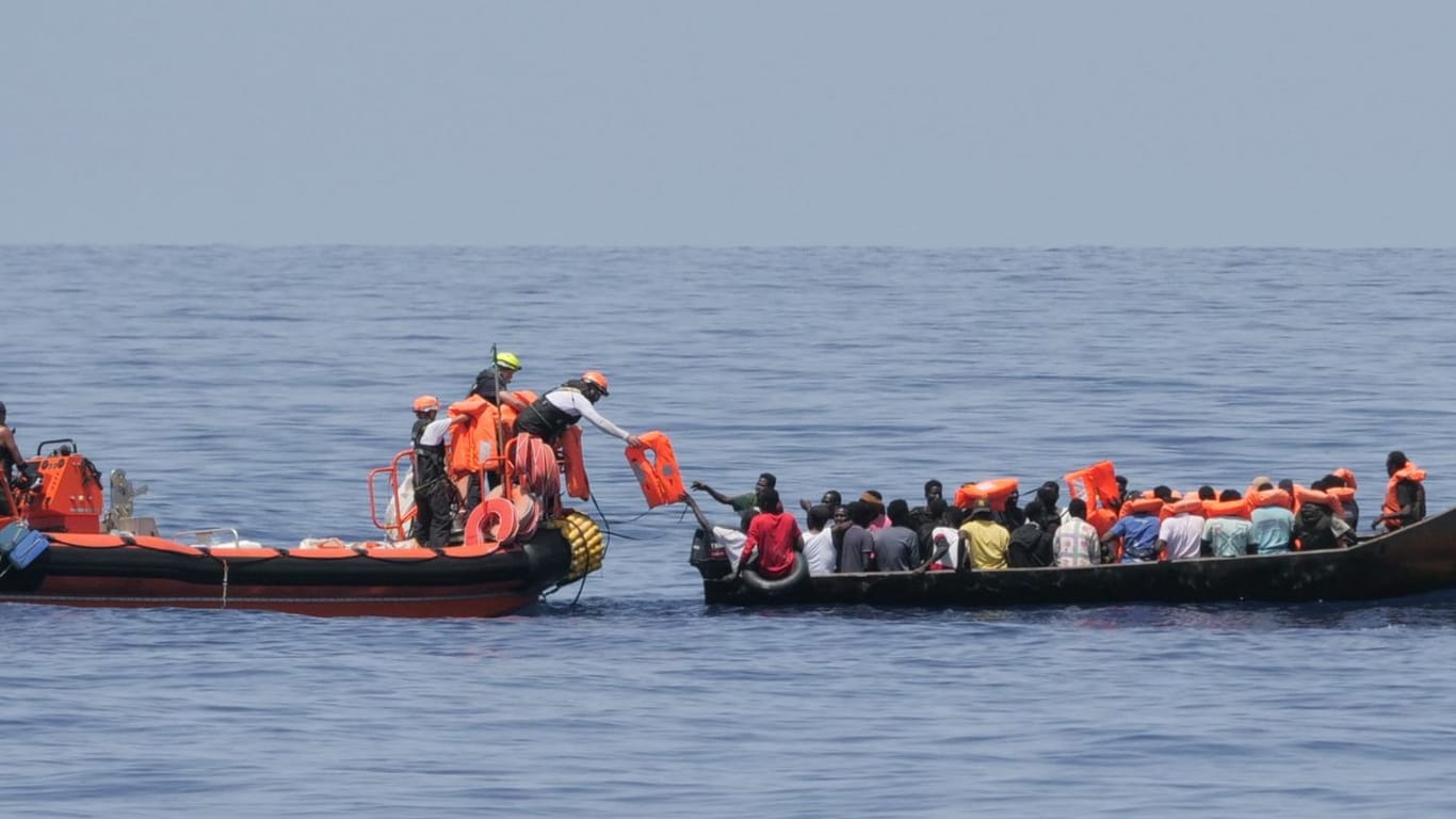 Retter der "Ocean Viking" helfen den Menschen in kleinen Booten im Mittelmeer.