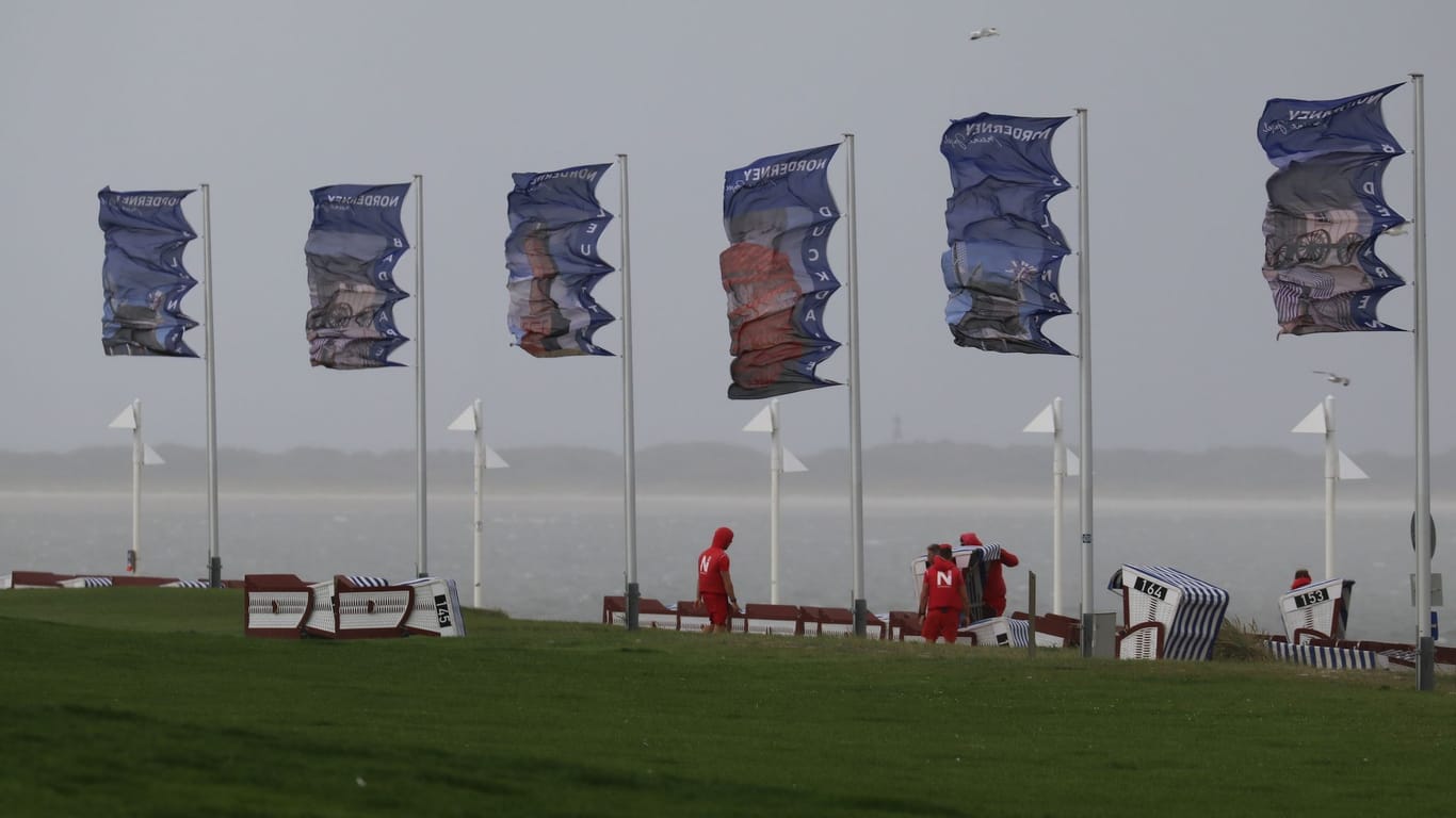 Bei starkem Nordwestwind wehen Fahnen an der Kaiserwiese auf der ostfriesischen Insel Norderney: Sommerurlauber und Küstenbewohner müssen sich auf ein für die Jahreszeit ungewöhnliches Sturmtief einstellen.