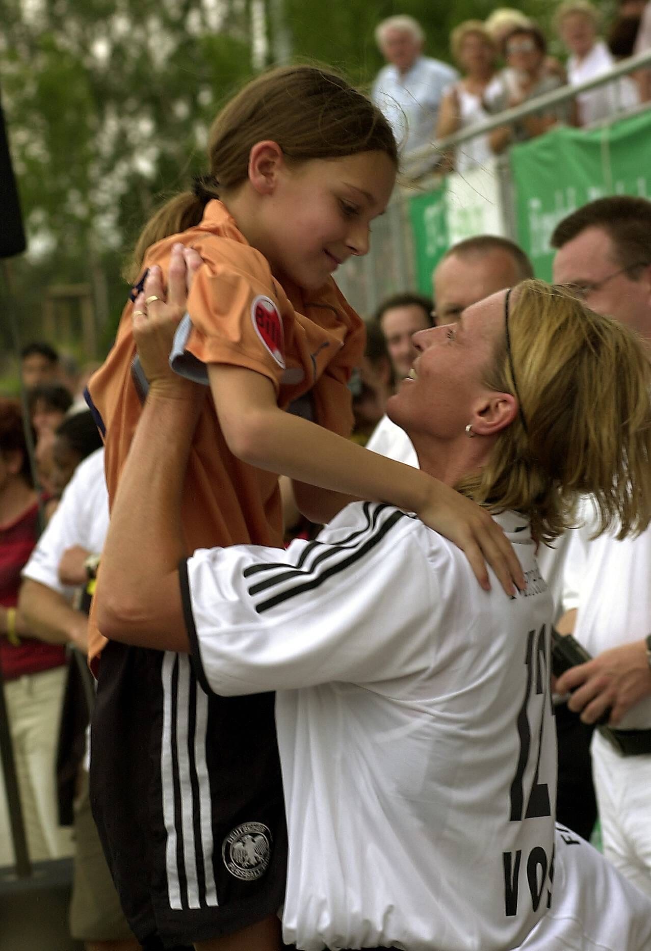 Die damalige Martina Voss hält nach ihrem Abschiedsspiel für Deutschland 2003 Tochter Dina in den Armen.