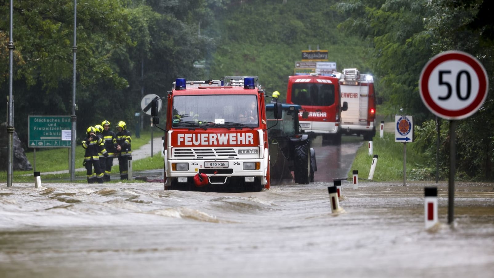 Feuerwehrleute vor einer überfluteten Brücke in der Steiermark: Am Sonntag wurde das erste Todesopfer in Österreich gemeldet.