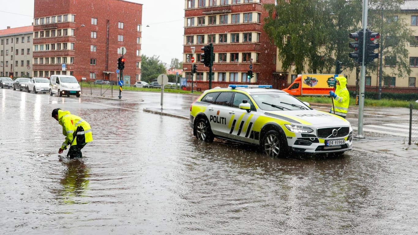 Polizeiauto auf überfluteter Straße in Oslo: Montag und Dienstag rechnen die norwegischen Meteorologen weiter mit Unwettern.
