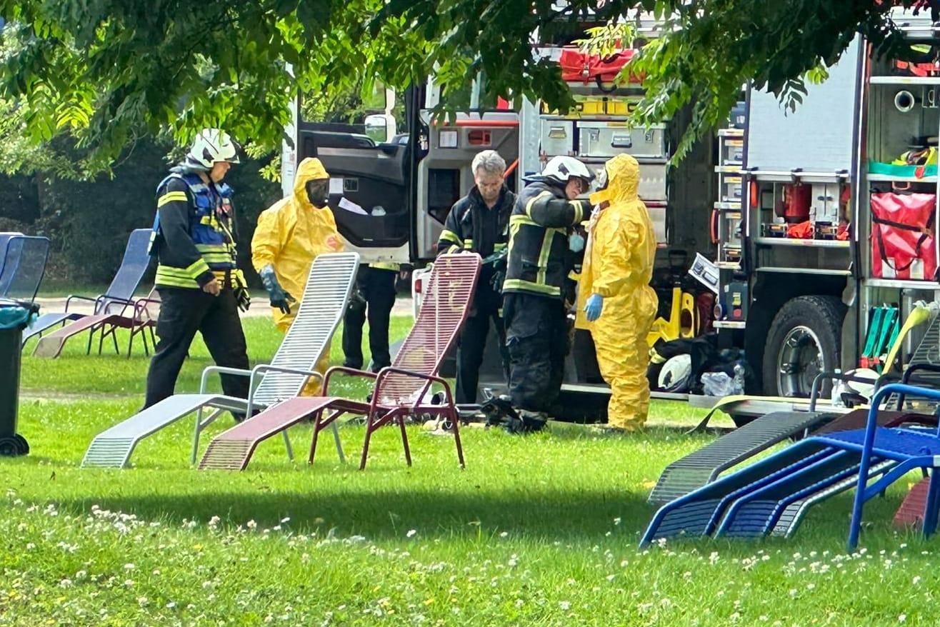 Feuerwehrleute in Vollschutz-Anzügen im Einsatz im Freizeitbad.