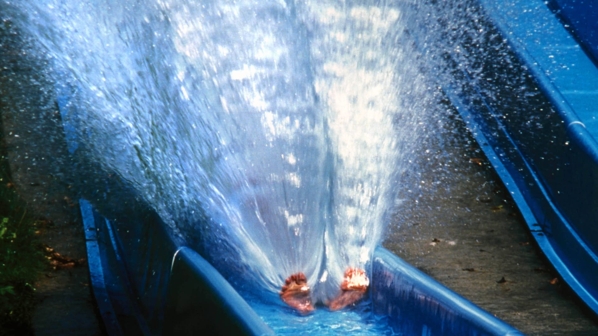 Eine Person nutzt eine Wasserrutsche in einem Freibad (Symbolbild): Insgesamt wurden drei Personen verletzt.