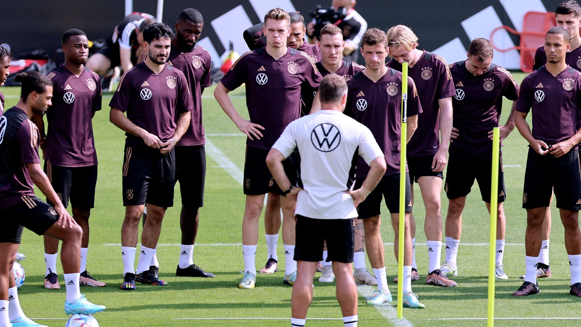 Hansi Flick (in weiß) hält eine Ansprache vor der Mannschaft im deutschen Basecamp in Katar.