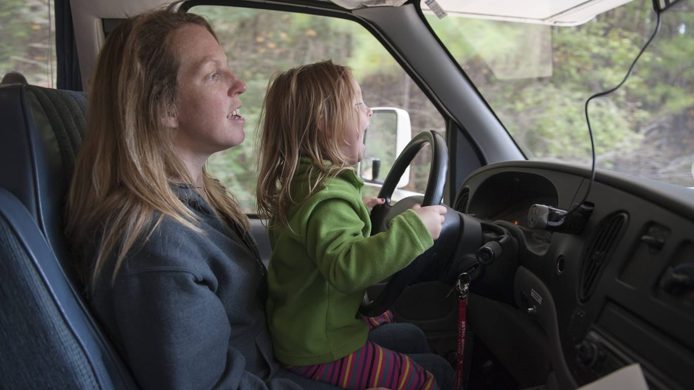 Eine Mutter lässt ihr Kind vom Schoß aus das Auto lenken: Das geht auf Kosten der Sicherheit.