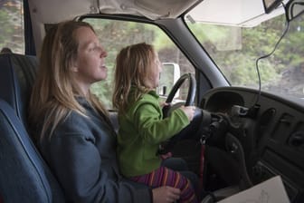 Eine Mutter lässt ihr Kind vom Schoß aus das Auto lenken: Das geht auf Kosten der Sicherheit.