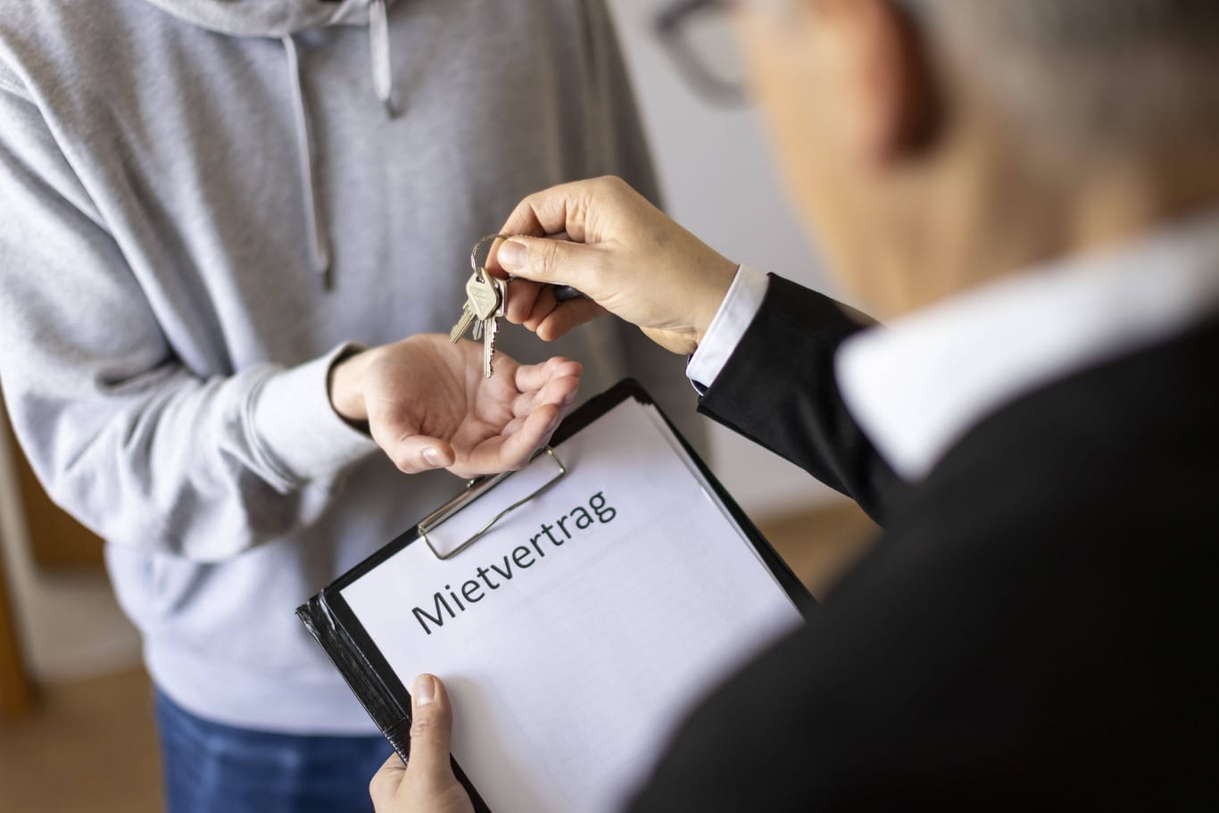 Ein Makler übergibt einen Schlüssel an einen neuen Mieter (Symbolbild): In München ist es nicht einfach, eine Wohnung zu finden.