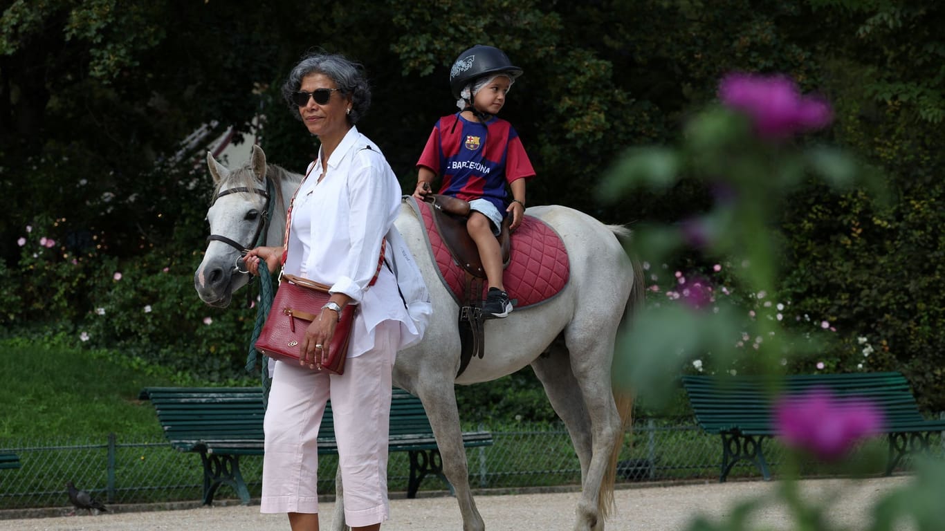 Eine Frau und ein Kind beim Ponyreiten: Aus Tierschutzgründen will die Stadt Paris das Ponyreiten nun verbieten.