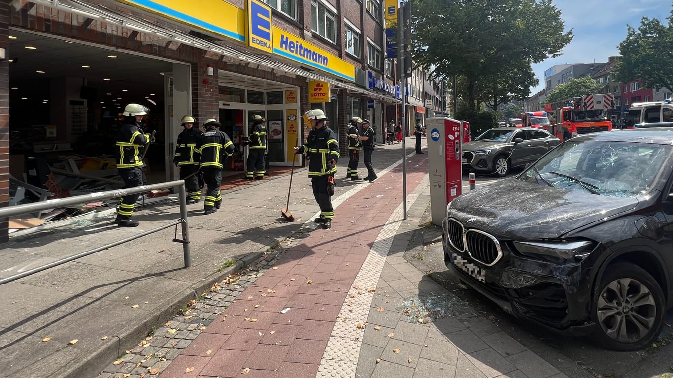 Der Unfallwagen steht vor dem Supermarkt: Die Frontscheibe des Geschäfts ist komplett demoliert.