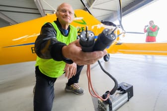 Testpilot Uwe Nortmann zeigt einen Spannungswandler vor dem E-Flugzeug "Elektra Trainer": Der Flieger war am Mittwoch in Hannover gelandet.
