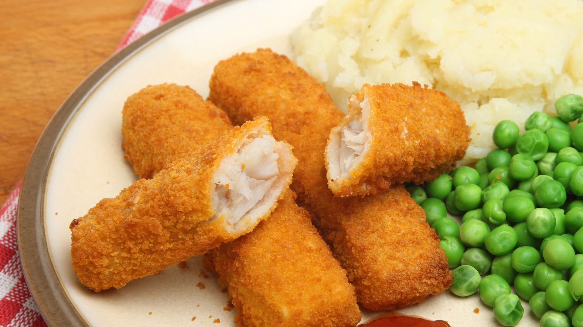 Fischstäbchen passen hervorragend zu Kartoffelbrei und Erbsen.