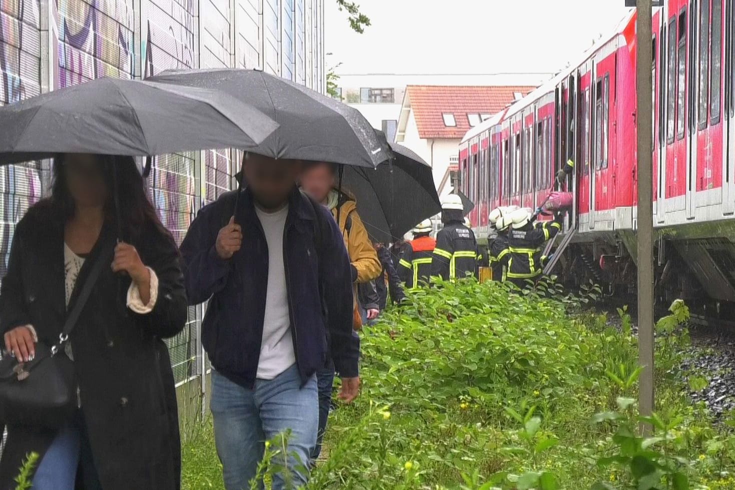 Fahrgäste laufen am Gleis entlang: Sie wurden mit Bussen und Taxen weitertransportiert.